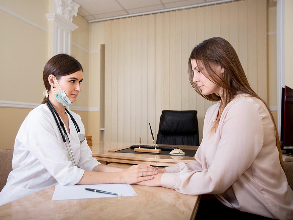 mujer hablando con doctor