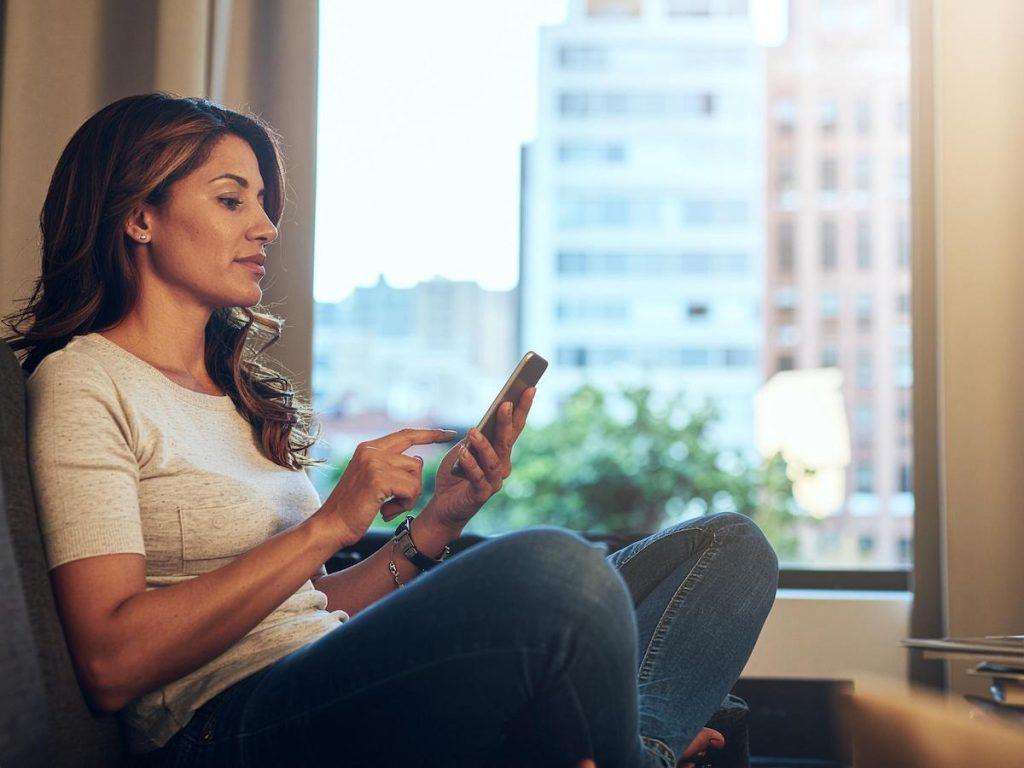 Mujer usando el teléfono con el app de Finhabits
